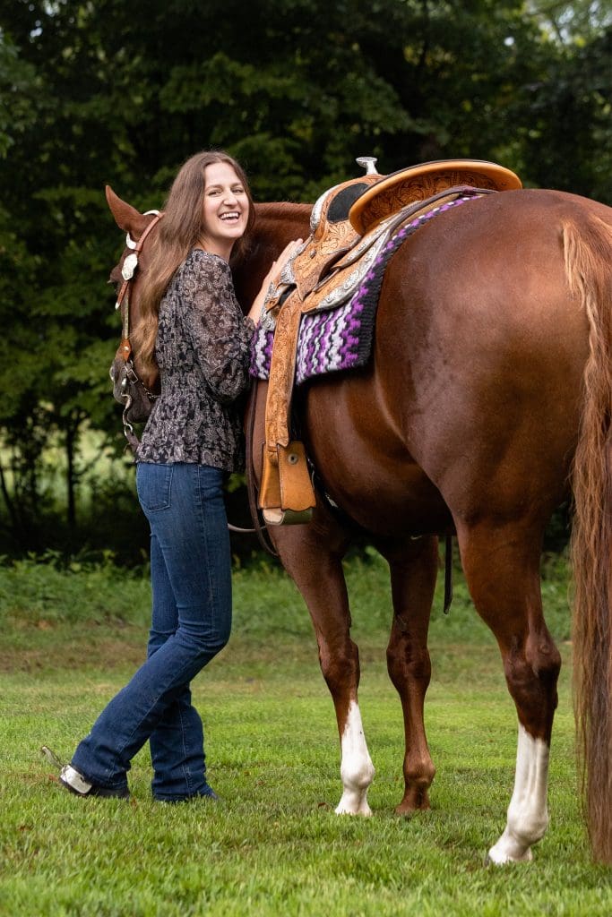 woman laughing with her horse and facing camera